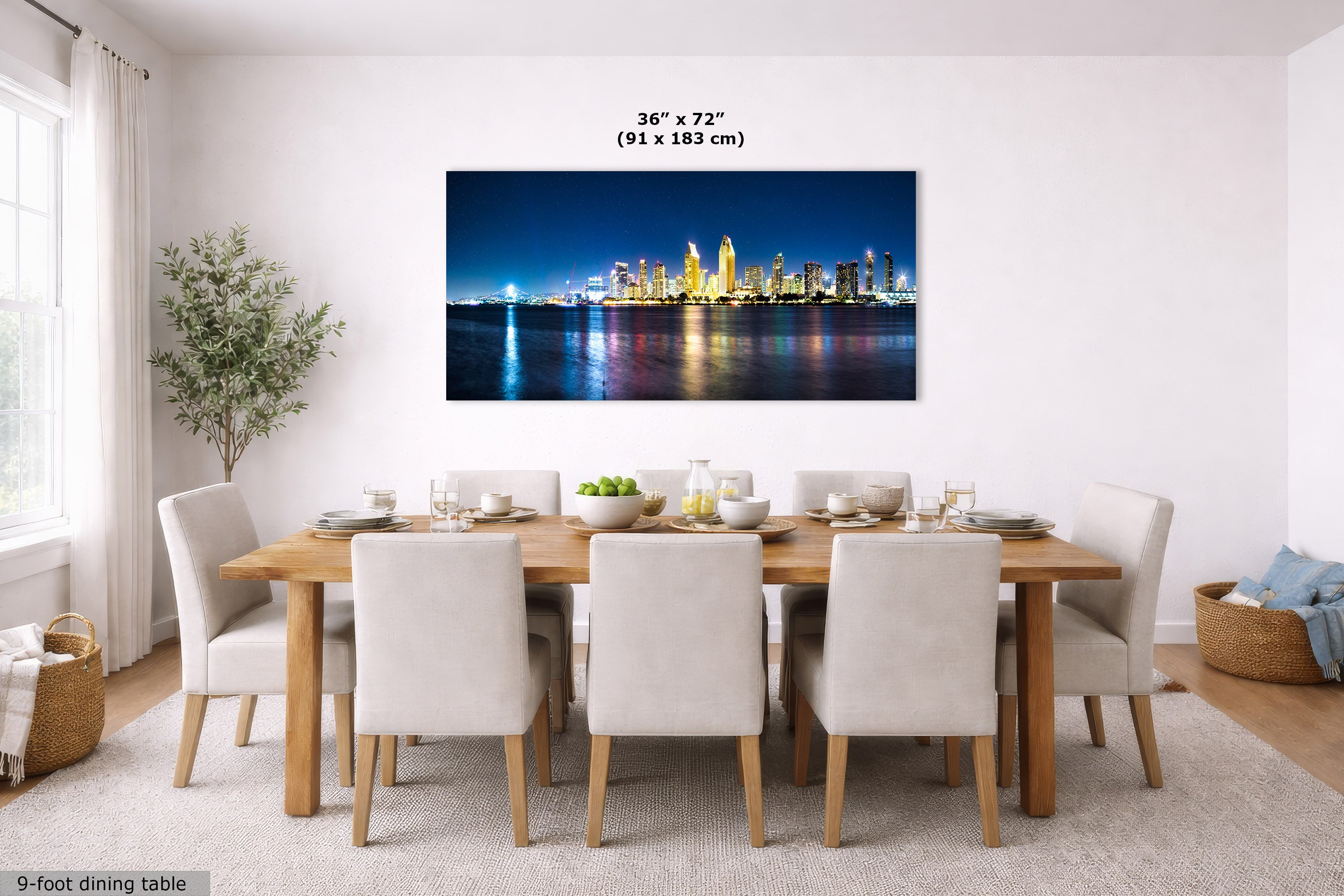 A framed wall art print showing a nighttime city skyline with illuminated skyscrapers and reflections on water, displayed above a dining table in a bright modern room. The print includes size text reading 36 x 72 inches (91 x 183 cm).