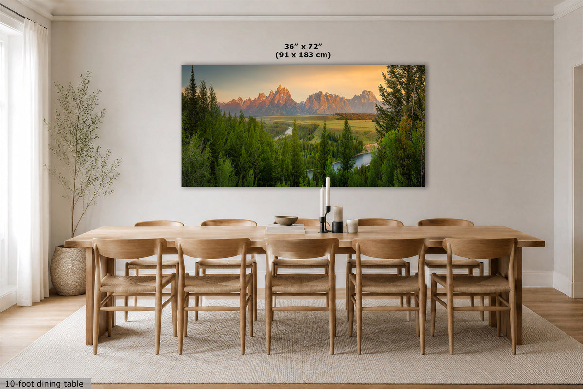 A large rectangular wall art print showing a mountain landscape at sunset hangs above a wooden dining table and chairs in a bright dining room. The print includes a size label reading 36 x 72 in (91 x 183 cm).