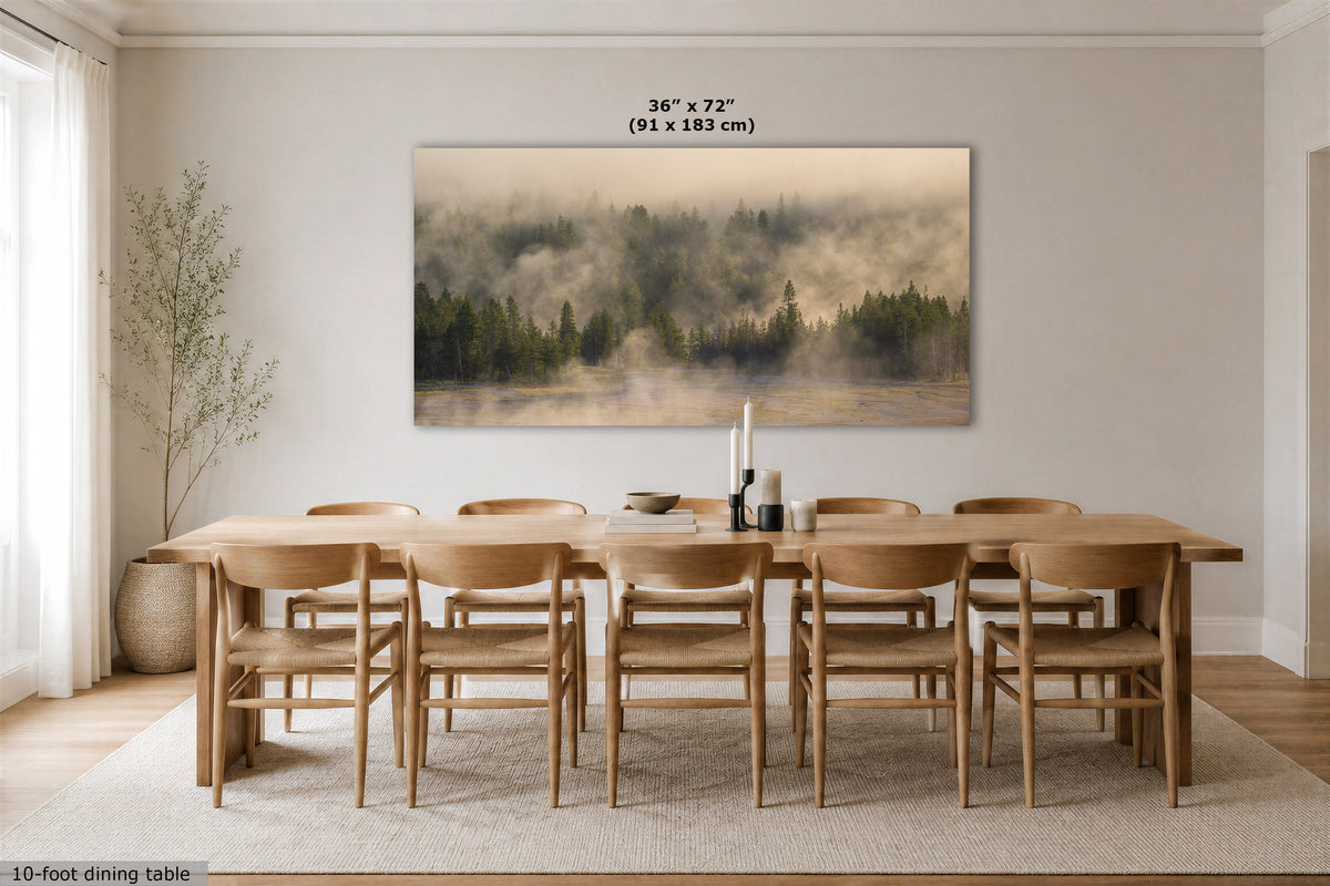 A large rectangular wall art print showing a misty forest landscape in muted beige, green, and brown tones, displayed above a wooden dining table and chairs in a bright modern dining room. Text above the artwork reads 36 x 72 (91 x 183 cm).
