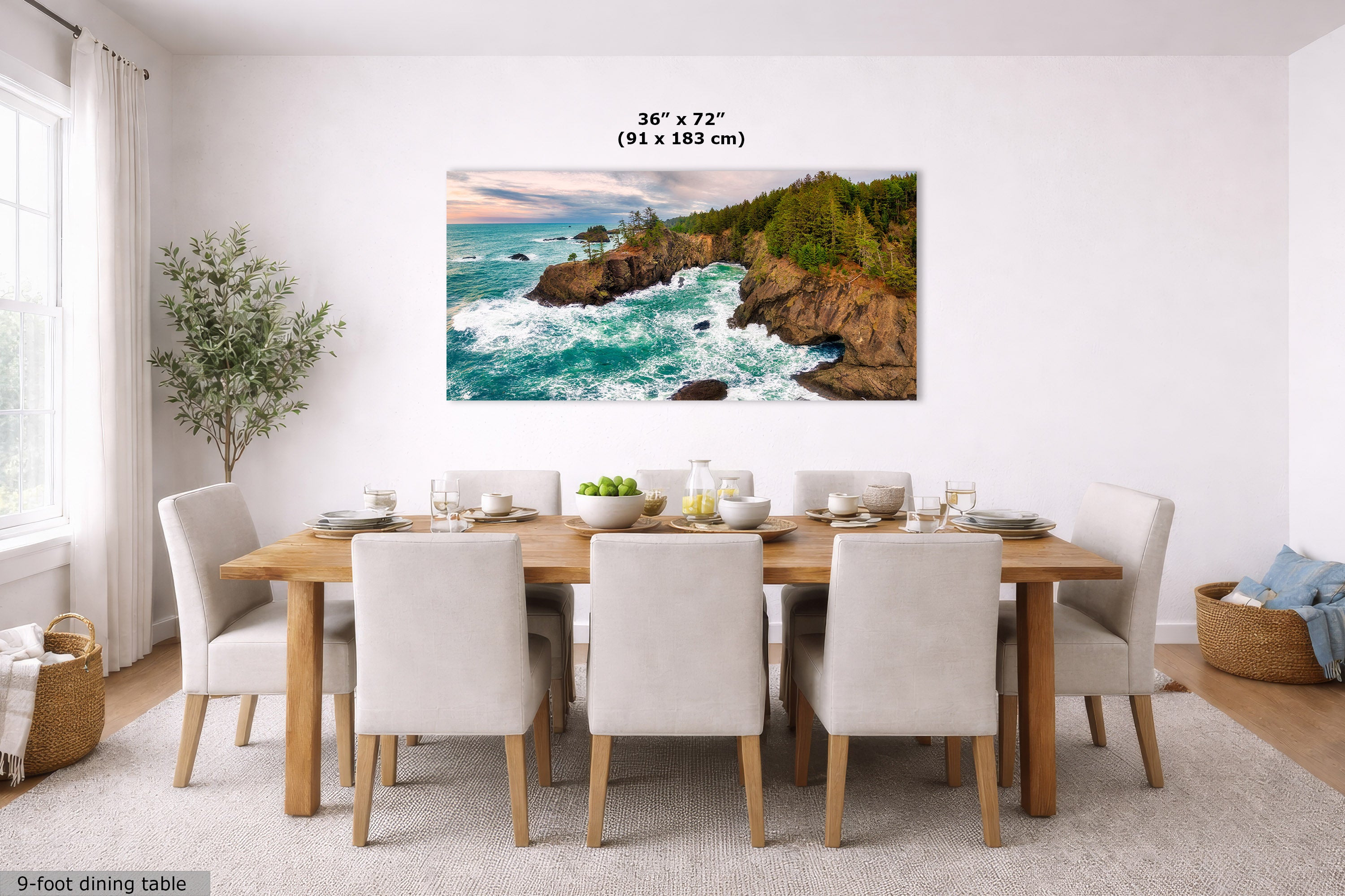 A wall art print showing a coastal rocky shoreline with turquoise waves and green cliffs, displayed above a dining table in a bright modern dining room. Text above the print reads 36 x 72 in (91 x 183 cm).