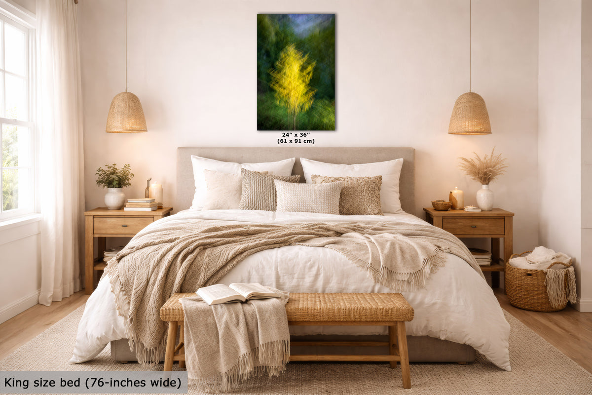 A framed vertical wall art print featuring a bright yellow tree or bush against a dark green and blue background, displayed above a neatly made bed in a bright, modern bedroom. The print includes size text reading 24 x 36 inches (61 x 91 cm).