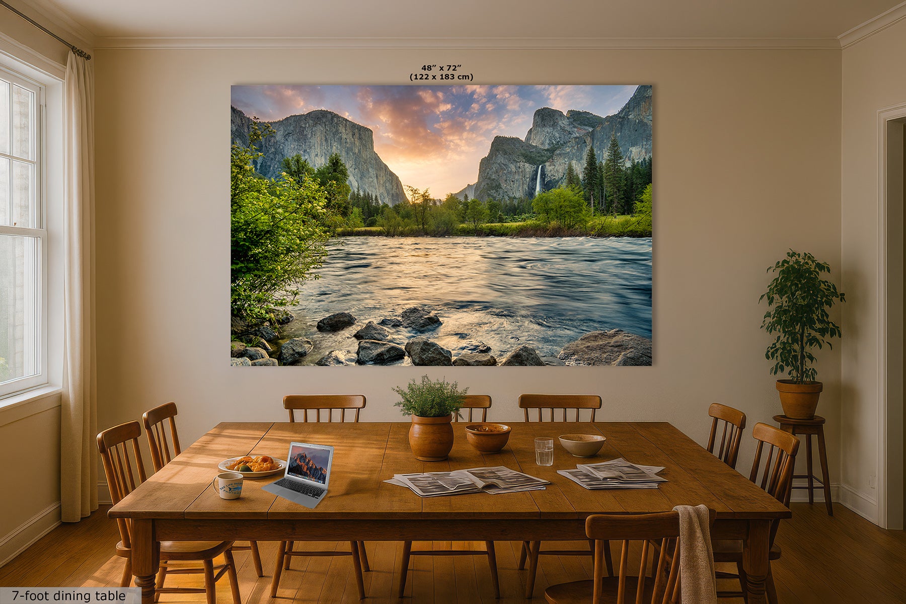 A large wall art print depicting a scenic Yosemite mountain landscape with the Merced River and Bridalveil Waterfall, displayed above a wooden dining table in a styled dining room. The print includes size text at the top and a small label at the bottom left.