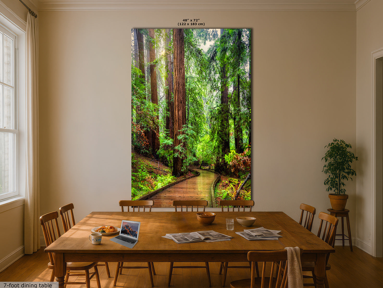 A large vertical wall art print depicting a lush green Redwood forest path with tall trees, displayed above a wooden dining table in a beige dining room. The print includes size text at the top and a small label for a 7-foot dining table at the bottom left.