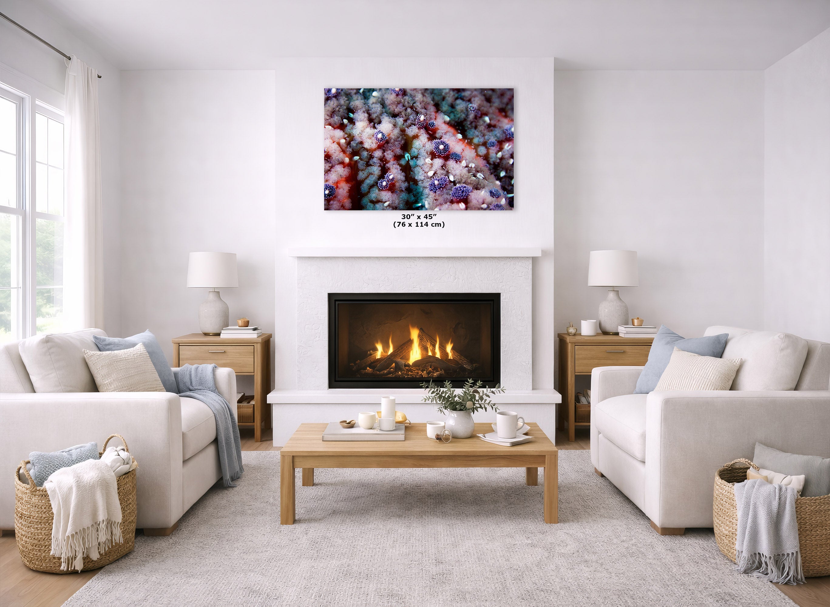 A colorful abstract canvas print displayed above a white fireplace in a bright, modern living room with two white sofas and a wooden coffee table.