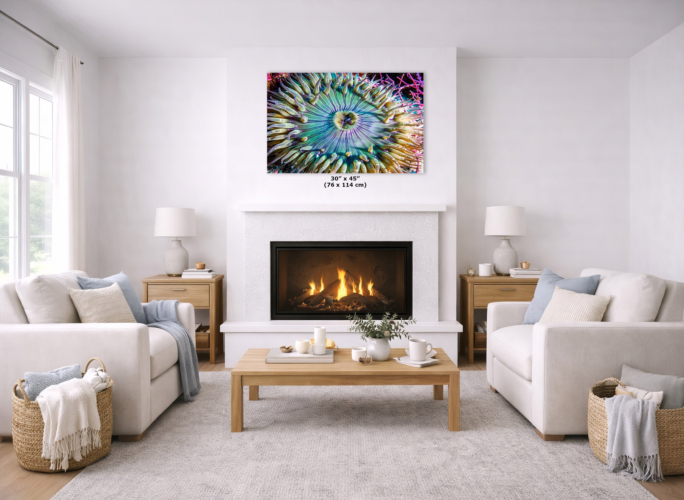 A colorful square wall art print depicting a vibrant, spiral-like floral or abstract design in turquoise, purple, yellow, and pink, displayed above a white fireplace in a bright, modern living room with two white sofas and a wooden coffee table.