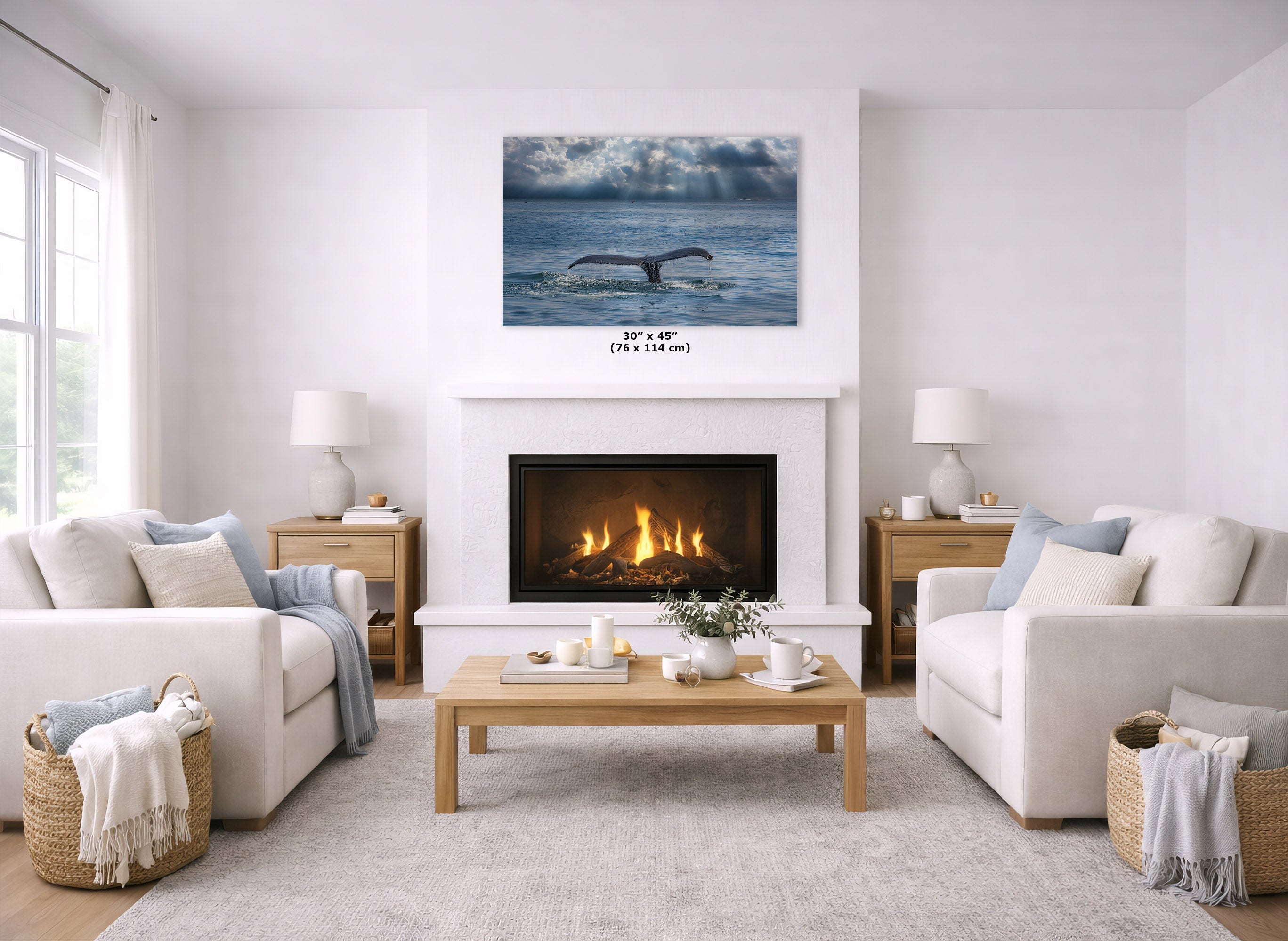 A whale print hanging above a fireplace in a bright, modern living room with two white sofas, a wooden coffee table, and woven baskets.
