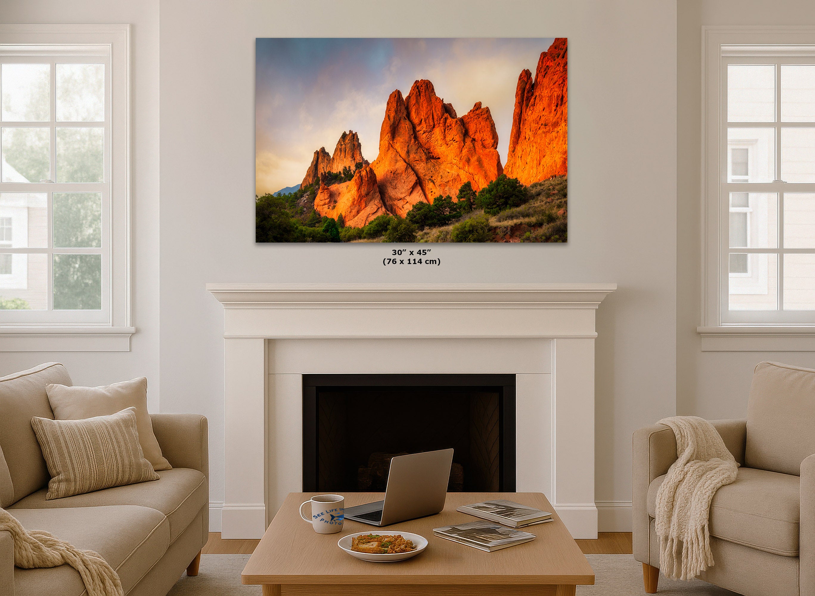 Living room with a large wall art displaying a mountain landscape, above a fireplace.