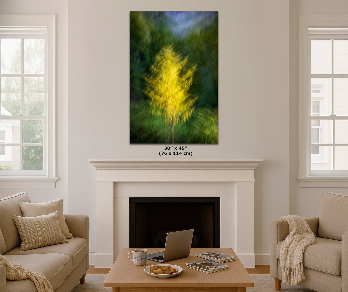 A framed vertical canvas print of a glowing yellow tree in a green forest, displayed on a white wall above a fireplace in a modern living room setting. The image includes a size label overlay: '30" x 45" (76 x 114 cm)'.