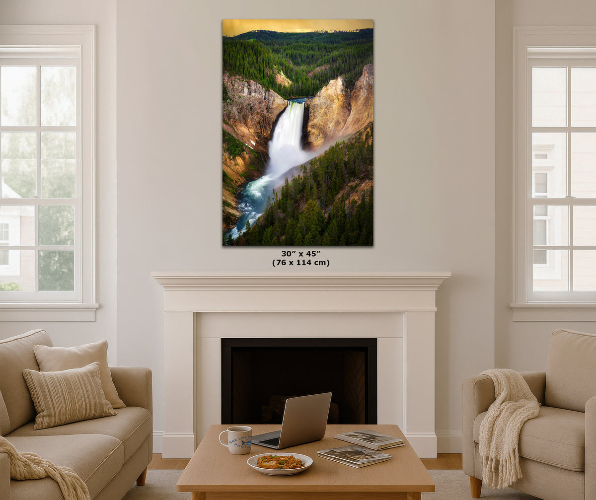 A vertical canvas print of a scenic waterfall in a forested canyon, displayed on a white wall above a fireplace in a modern living room setting. The print features a 30" x 45" size label below it.