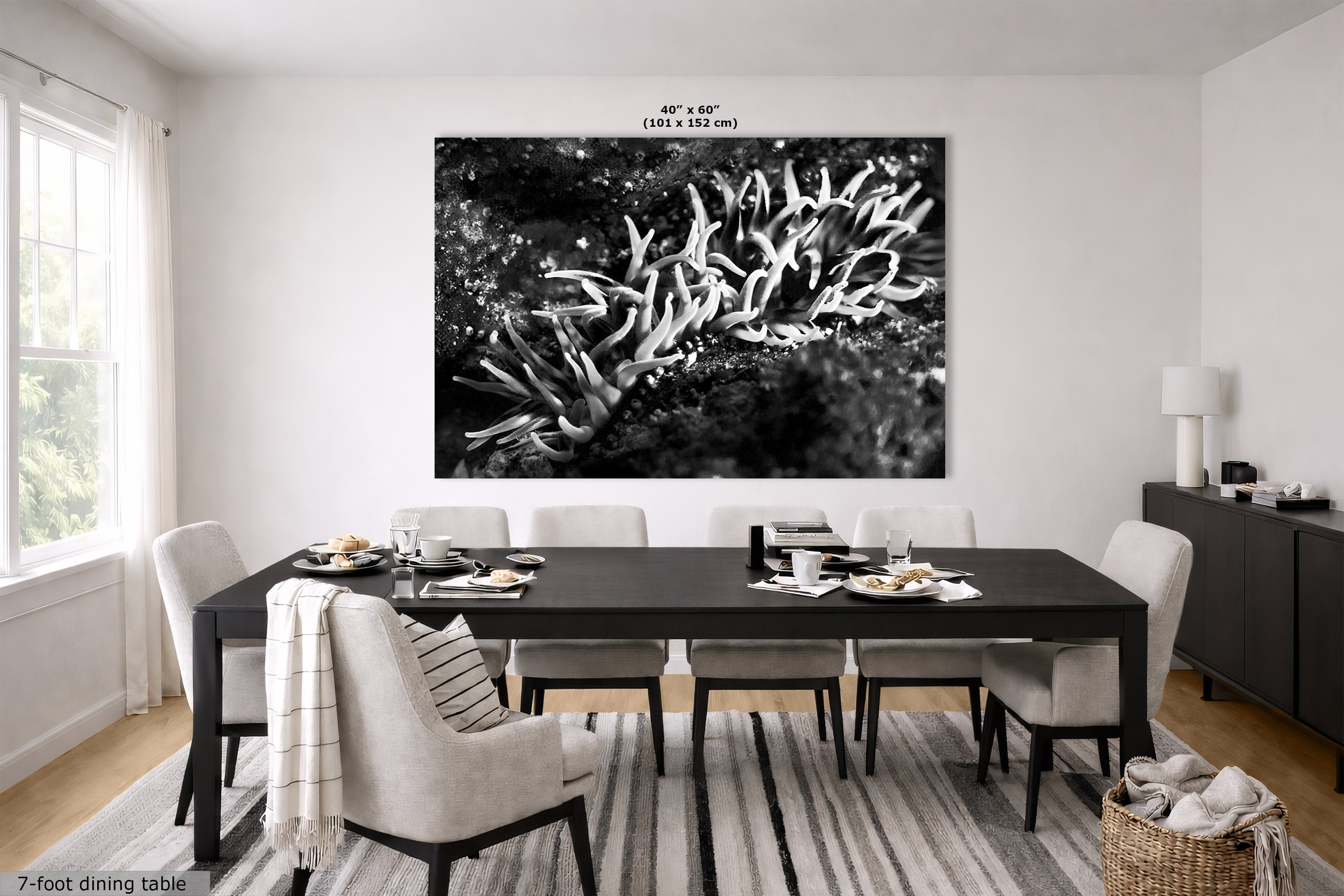 A large black and white wall art print depicting coral or anemone-like marine life, displayed above a dining table in a modern dining room. The print includes size text at the top and a 7-foot dining table label at the bottom left.