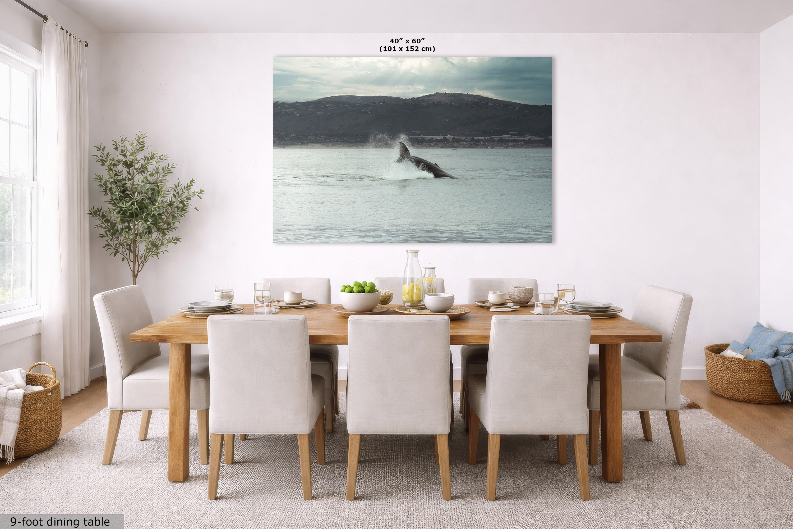 A large rectangular wall art print showing a whale breaching in the water, displayed in a bright dining room above a wooden dining table and chairs. The print has text at the top reading 40 x 60 inches.