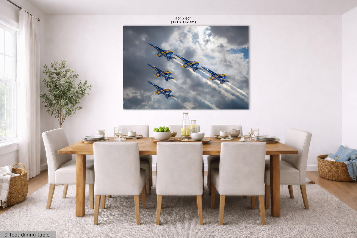 A large rectangular wall art print showing four blue and yellow aircraft flying through dramatic clouds, displayed above a wooden dining table with white chairs in a bright modern dining room. The print has small size text above it reading 40 in x 60 in.