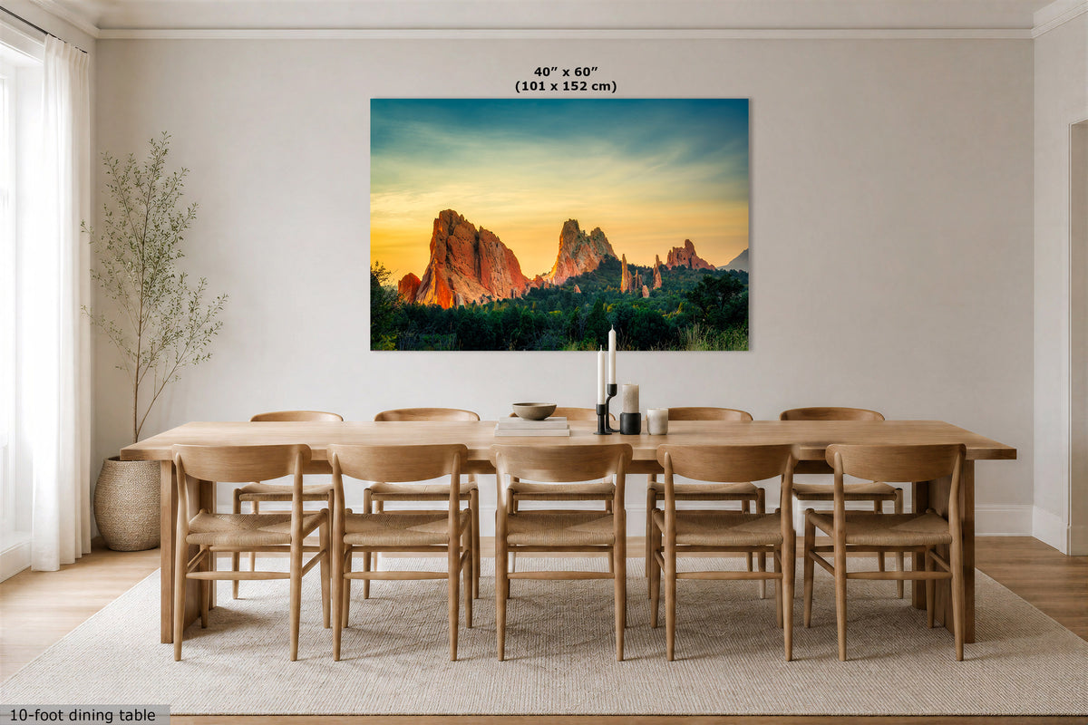 A large wall art print showing a desert rock landscape at sunset hangs above a 10-foot dining table and chairs in a bright neutral dining room. The print includes the text '40" x 60" (101 x 152 cm)' at the top.