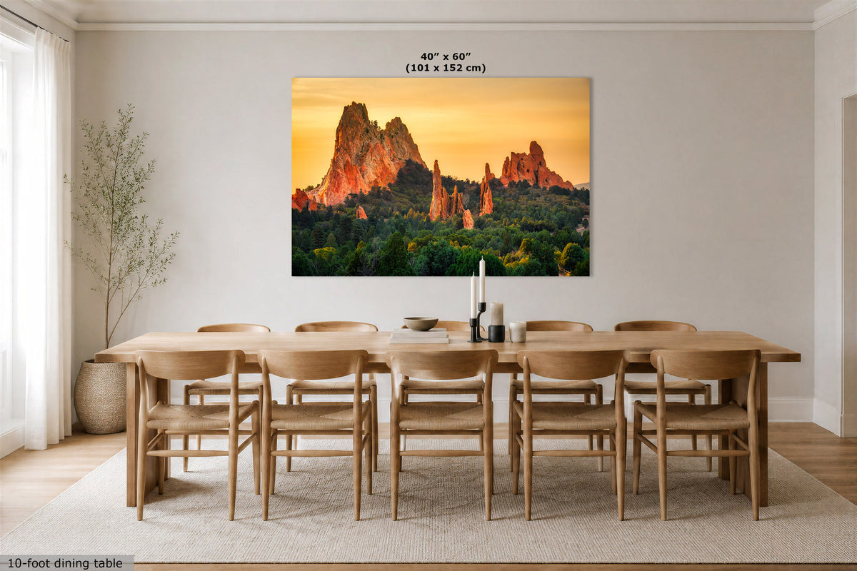 A large rectangular wall art print showing a desert rock landscape at sunset hangs above a wooden dining table and chairs in a bright, modern dining room. The print includes the text '40" x 60" (101 x 152 cm)' near the top.