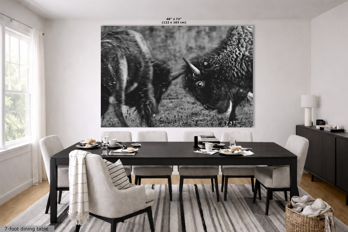 A large black and white wall art print depicting two bison facing each other, displayed in a modern dining room setting above a dark wood dining table and chairs. The print has dimensions labeled at the top (48" x 72" or 122 x 183 cm).