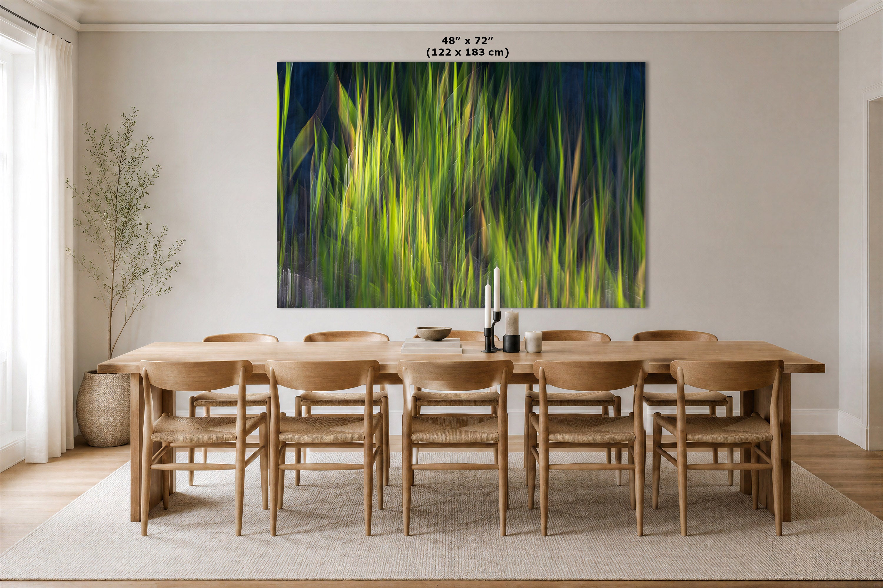 A large rectangular wall art print showing a close-up of bright green grass or reeds against a dark navy background, displayed above a wooden dining table and chairs in a modern dining room. The print includes size text at the top reading 48 x 72" (122 x 183 cm).