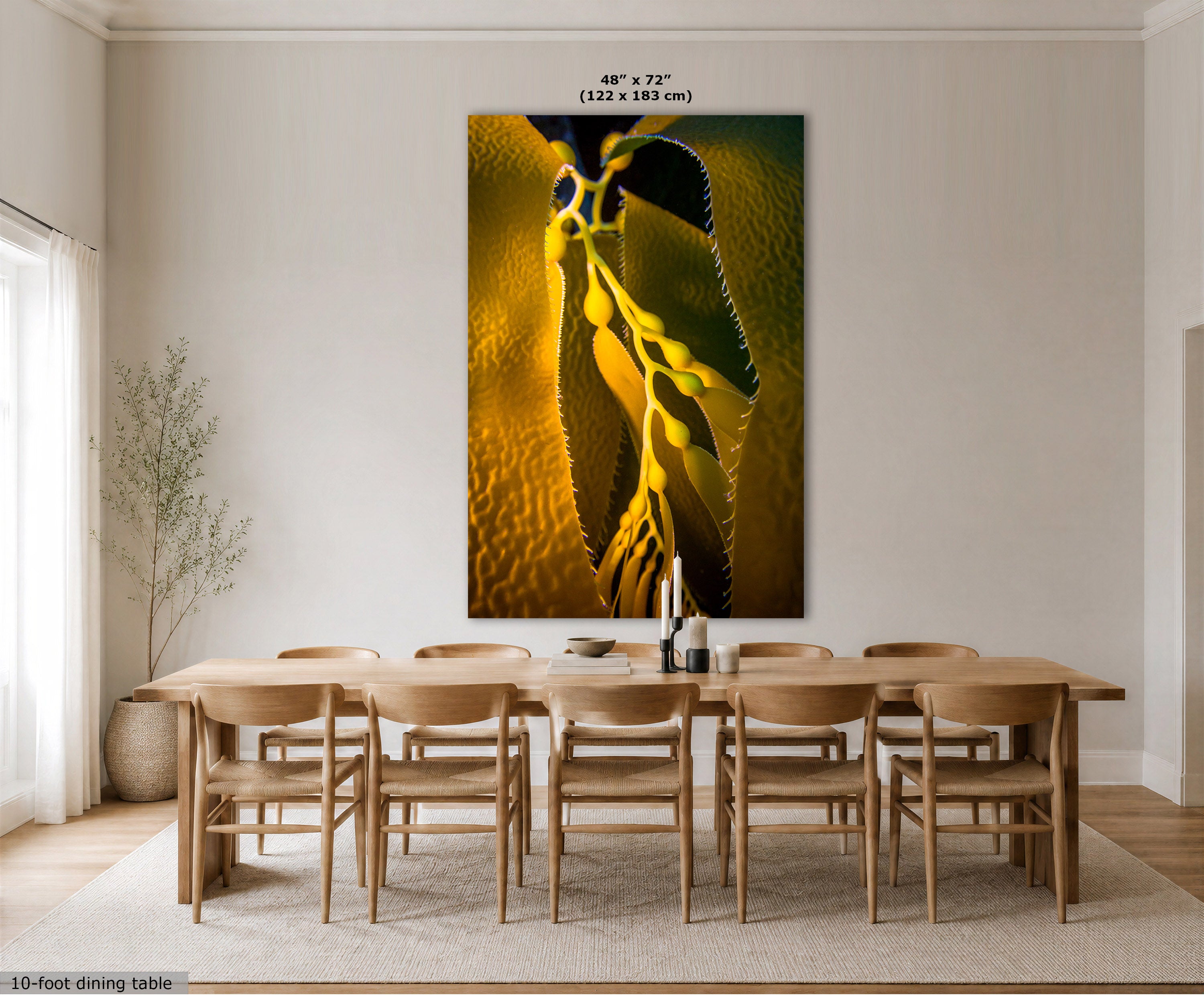 A large vertical wall art print showing a close-up abstract underwater photo of kelp, displayed above a wooden dining table and chairs in a bright neutral dining room. Text at the top reads 48" x 72" (122 x 183 cm), and a small note at bottom left says 10-foot dining table.