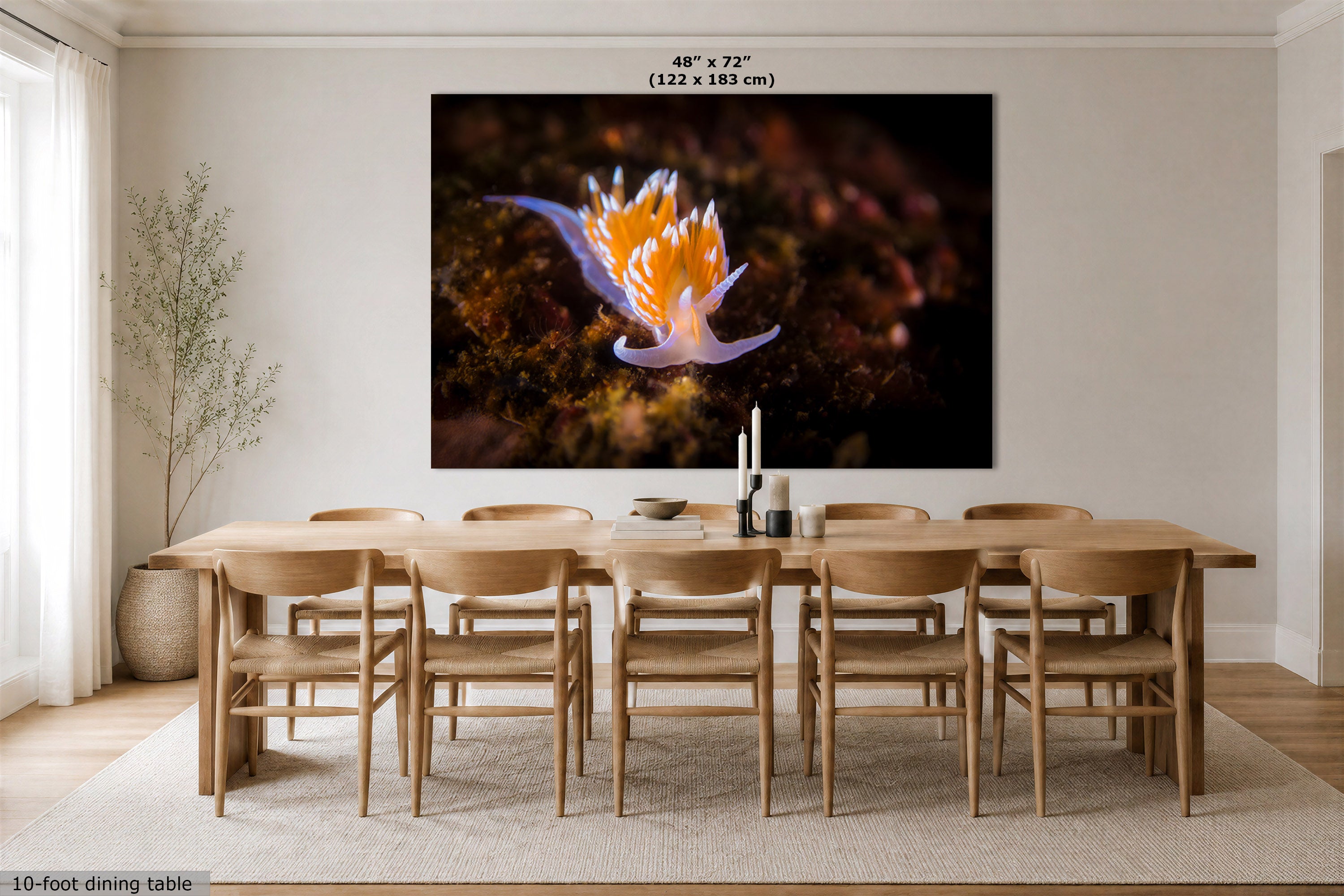 A large wall art print showing a close-up of a purple and orange nudibranch undersea scene, displayed above a wooden dining table and chairs in a bright, modern dining room. The print includes size text at the top indicating 48" x 72" (122 x 183 cm).