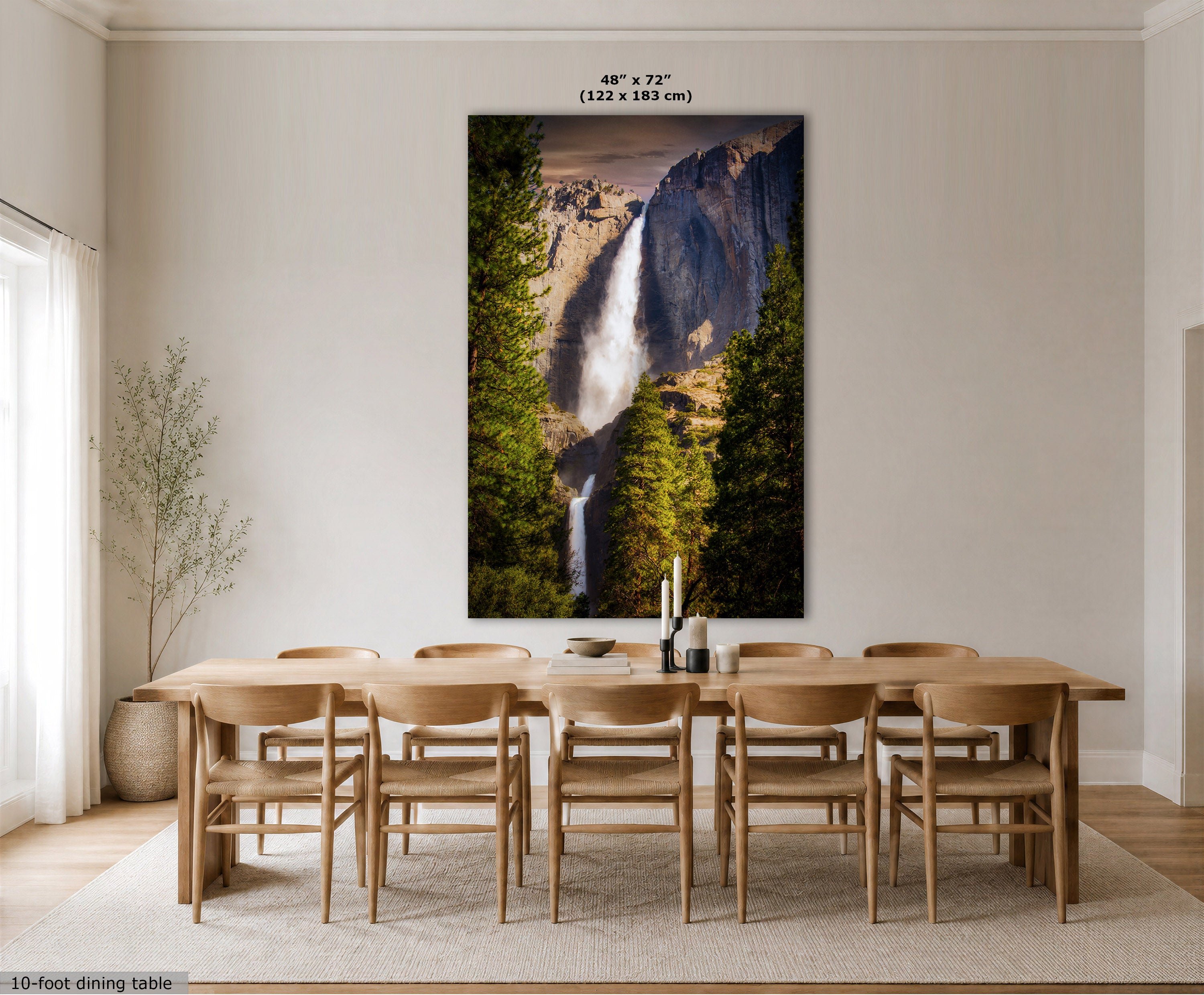 A large vertical wall art print showing a waterfall in a forest canyon, displayed above a wooden dining table and chairs in a bright, modern dining room. The print includes size text at the top reading 48" x 72" (122 x 183 cm).