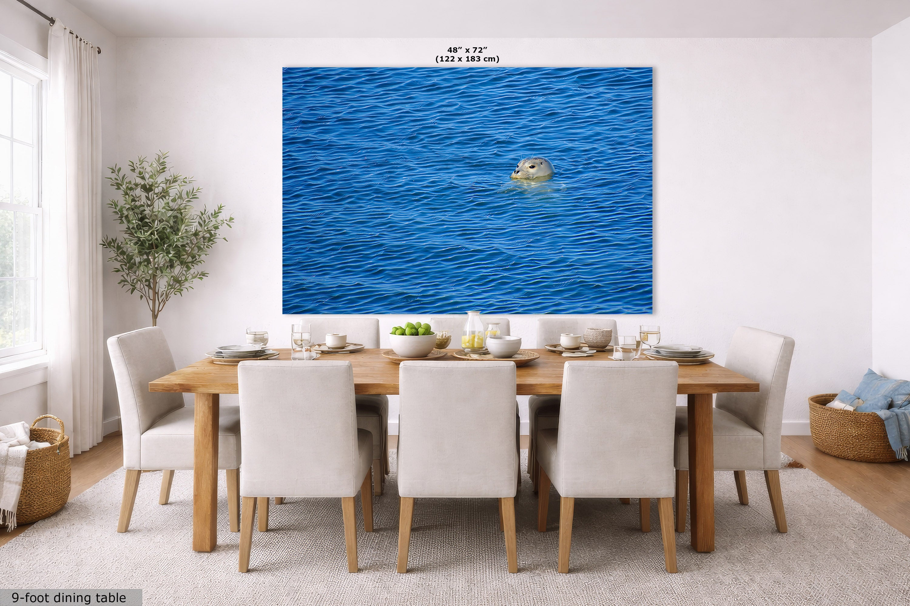 A large wall art print depicting a seal swimming in blue ocean water, displayed in a staged dining room above a wooden dining table and chairs. The print includes size text at the top and a label at the bottom left.