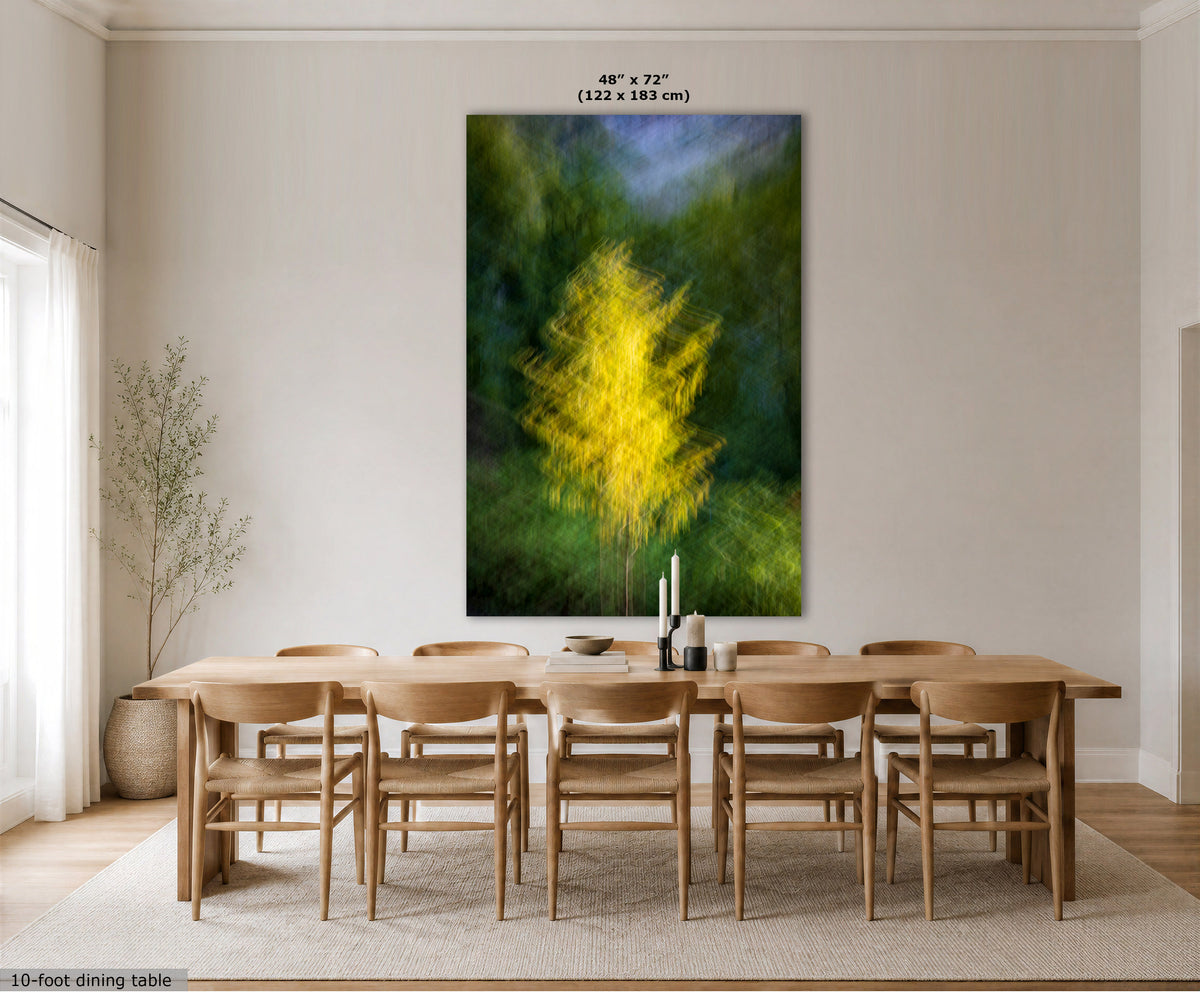 A large vertical wall art print showing an abstract yellow tree on a green and blue background, displayed above a wooden dining table and chairs in a bright, modern dining room. The print has a measurement label at the top indicating 48" x 72" (122 x 183 cm).