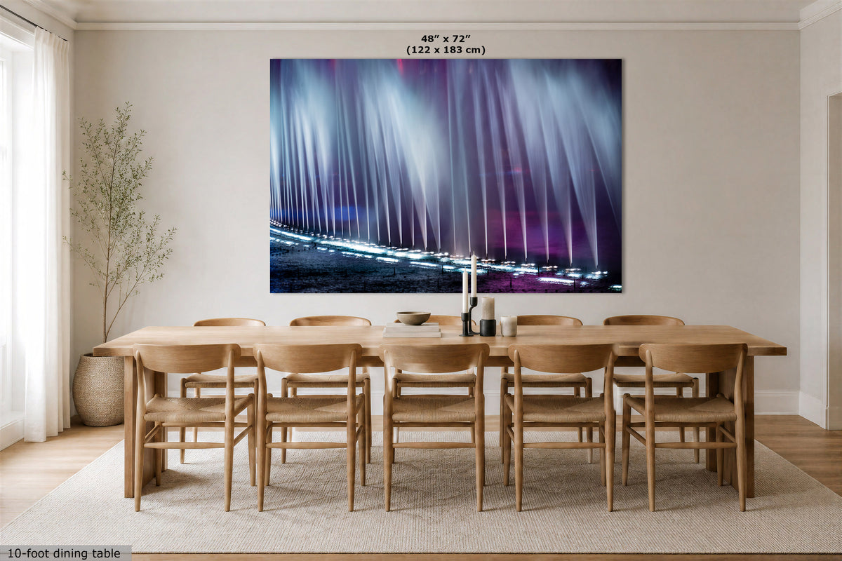 A large rectangular wall art print showing vertical light beams in blue, white, and purple tones, displayed above a wooden dining table and chairs in a bright neutral dining room. Text at the top reads 48" x 72" (122 x 183 cm).