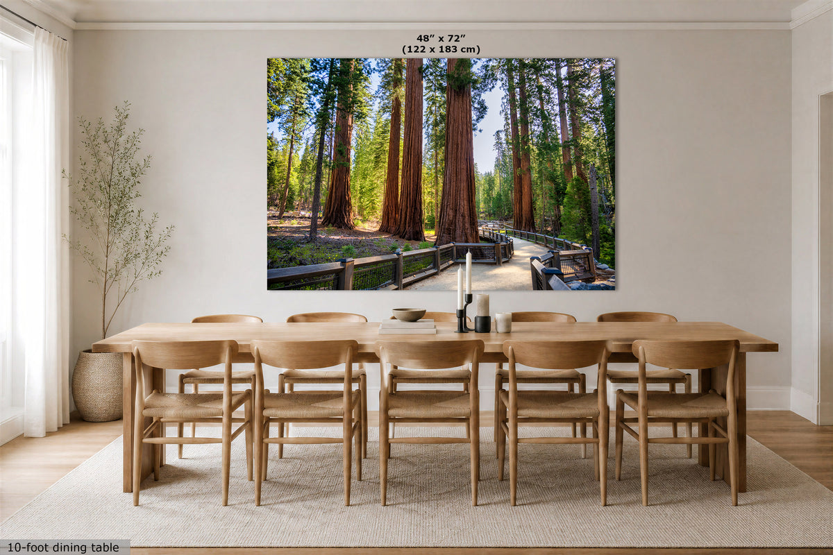 A large wall art print showing a forest path lined with giant redwood trees, displayed above a wooden dining table and chairs in a bright, modern dining room. The print includes size text at the top indicating 48" x 72" or 122 x 183 cm.
