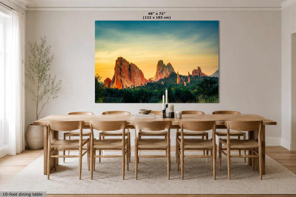 A large wall art print depicting a desert rock landscape at sunset hangs above a dining table and chairs in a bright, modern dining room. The print includes size text at the top reading 48 x 72" (122 x 183 cm).