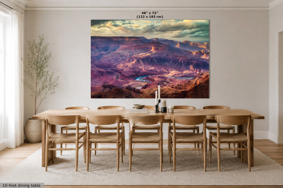 A large rectangular wall art print showing a colorful canyon landscape with purple, pink, blue, and orange tones, displayed above a wooden dining table in a bright dining room. Text at the top reads 48" x 72" (122 x 183 cm), and text at the bottom left says 10-foot dining table.