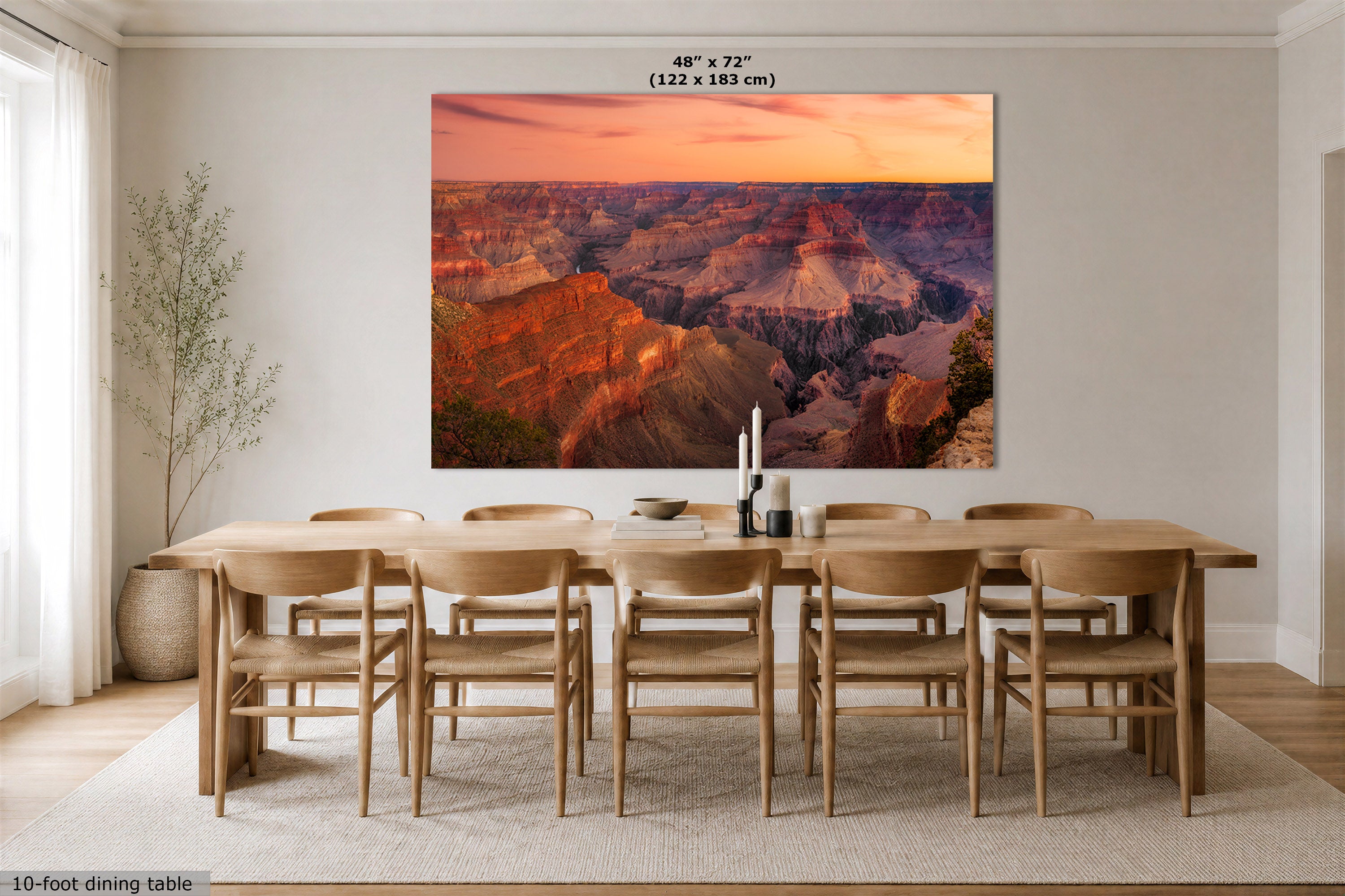 A large rectangular wall art print showing the Grand Canyon at sunset, displayed above a wooden dining table and chairs in a bright modern dining room. The print includes size text at the top reading 48" x 72" (122 x 183 cm).