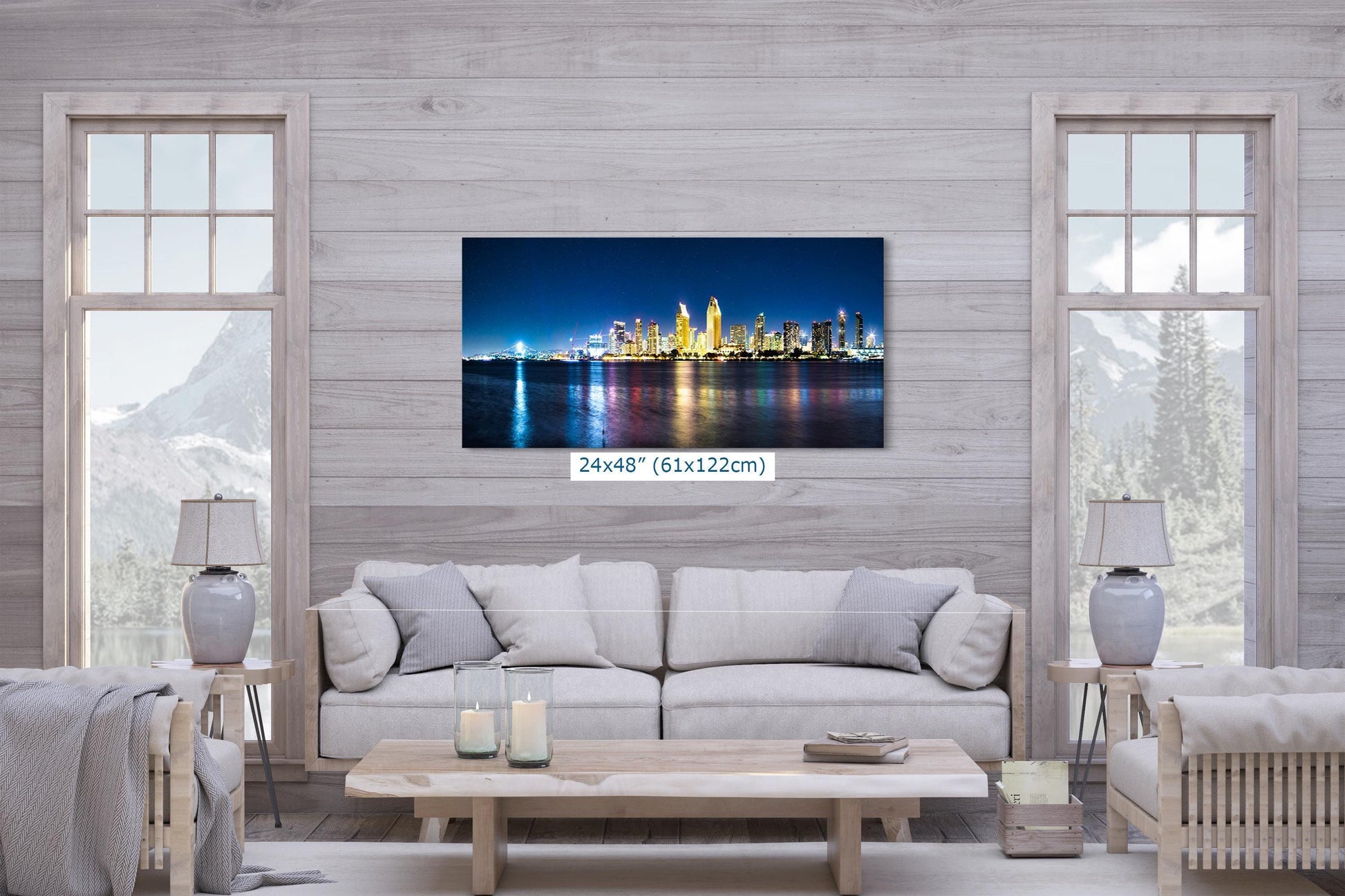 Large San Diego skyline wall art in a living room, 24x48 inch size, featuring the glowing cityscape reflected in the water at night.