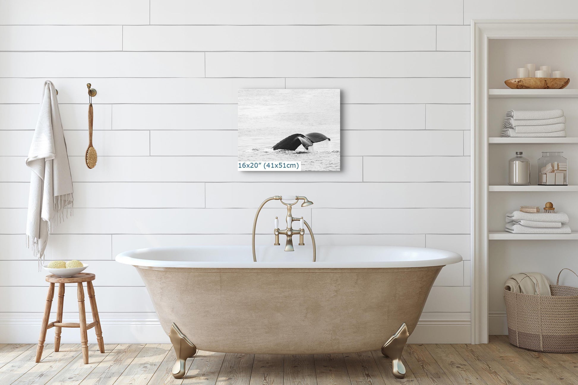 High-key black and white wall art of a humpback whale fluke displayed in a bathroom setting, size 16x20 inches.