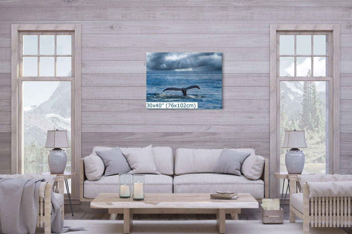 Humpback whale fluke wall art, sized 30x40 inches, displayed above a light-colored sofa in a cozy living room with mountain views through the windows.