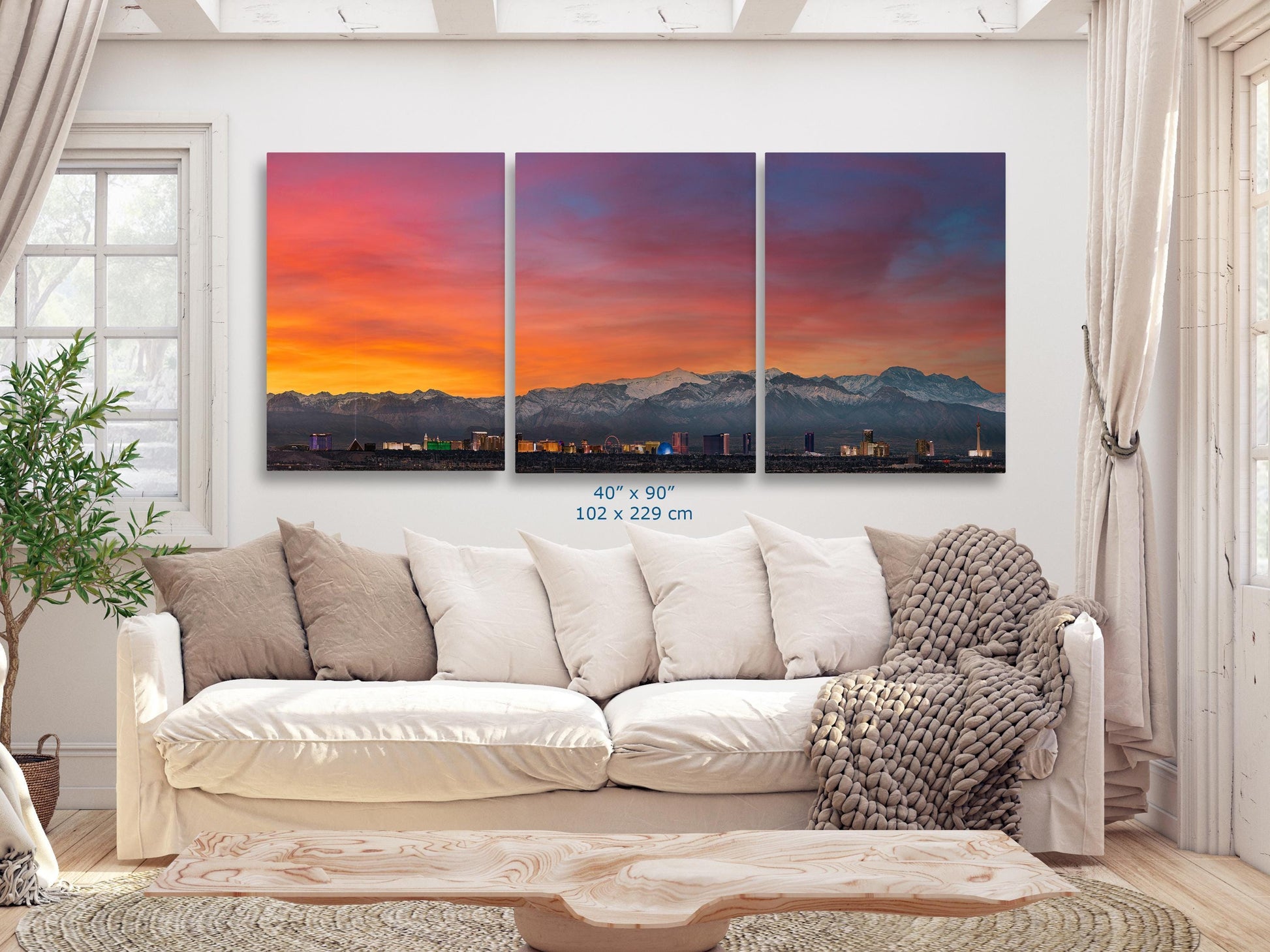 40x90 three-panel canvas print of the Las Vegas skyline at sunset displayed above a white couch in a living room.