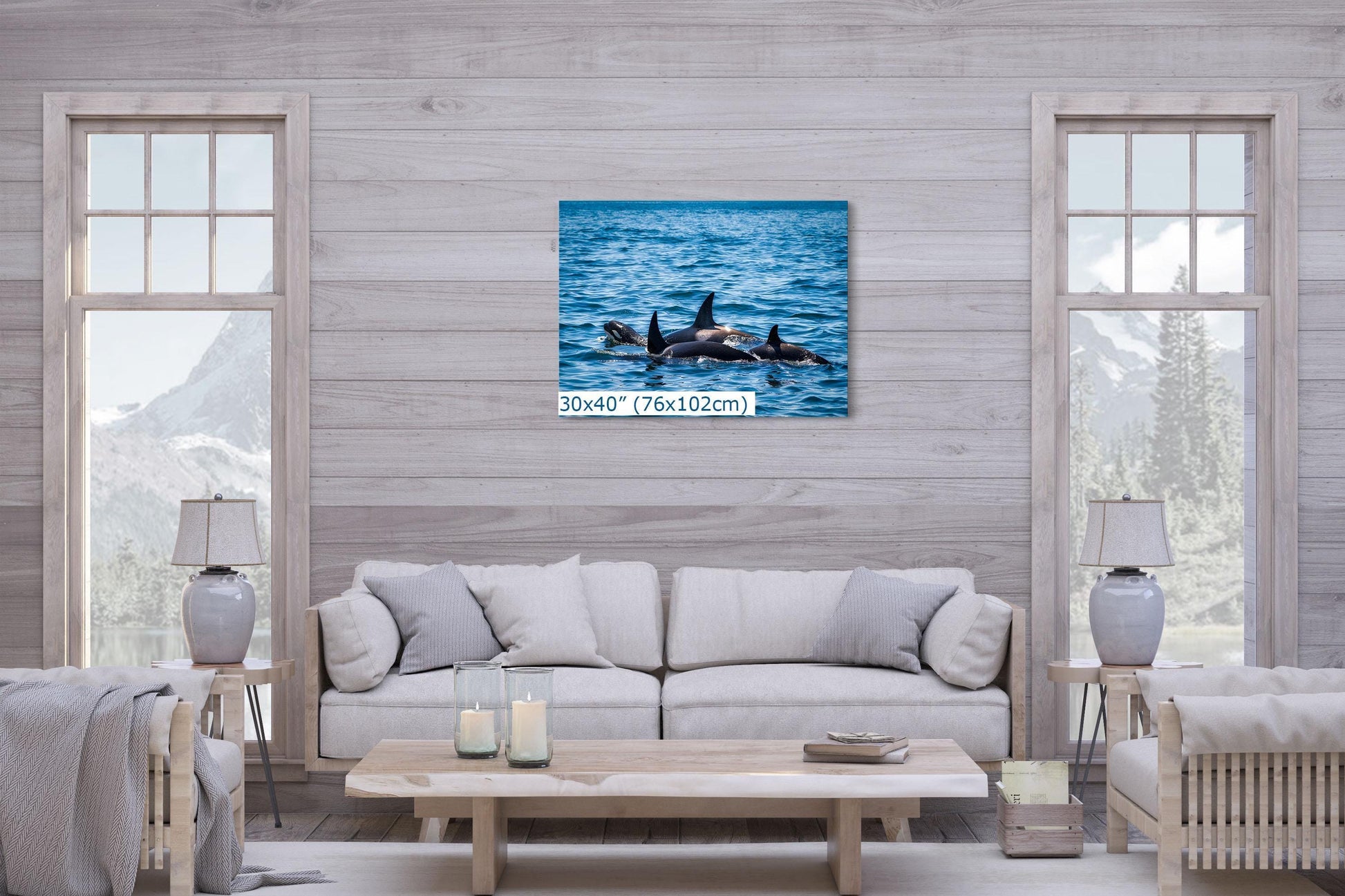 Orca (Killer Whale) family wall art, sized 30x40 inches, displayed above a light-colored sofa in a cozy living room with mountain views.