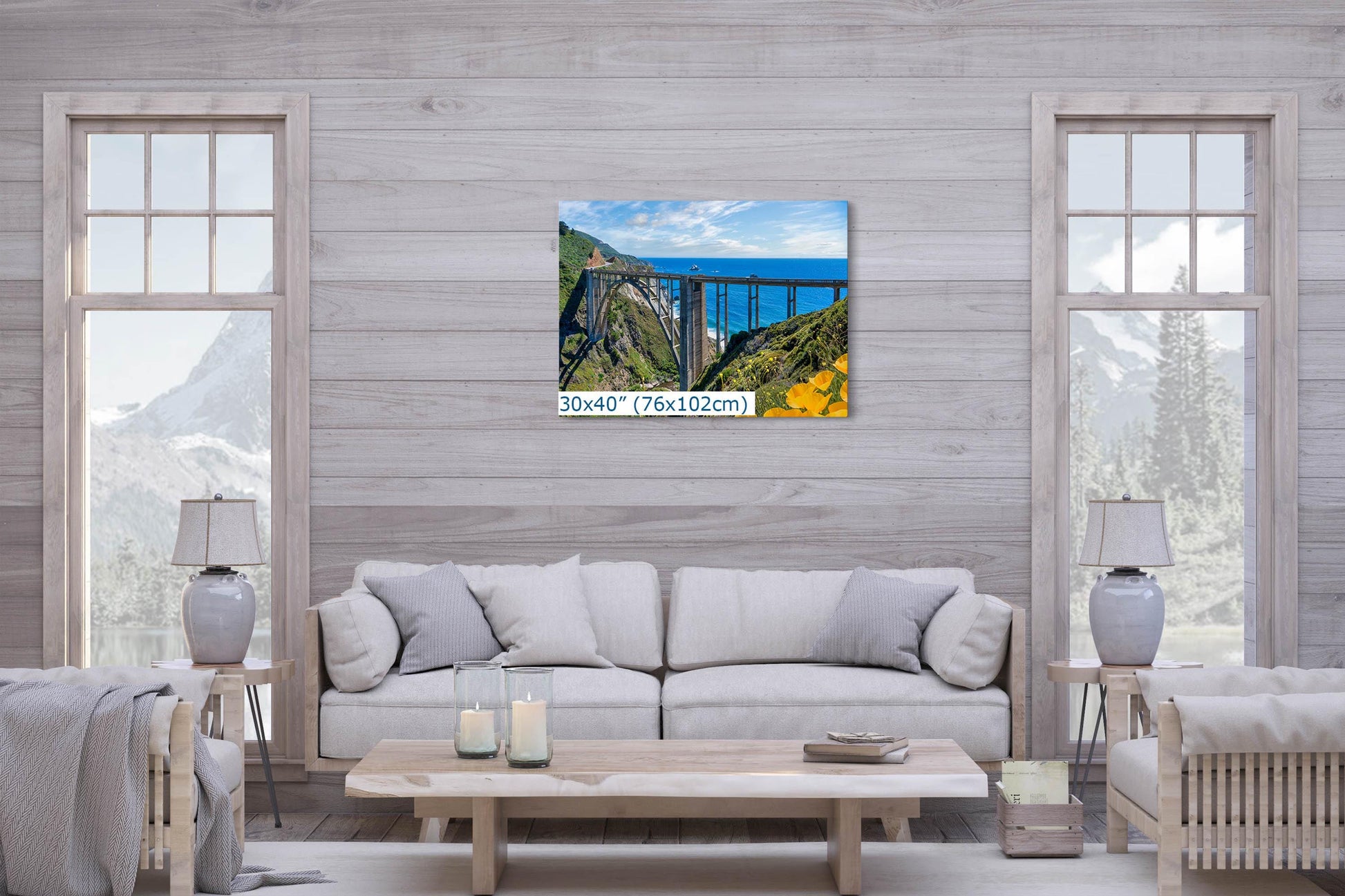 Wall art photograph of Bixby Bridge on the Big Sur coast of California, displayed above a couch in a modern living room, size 30x40 inches.