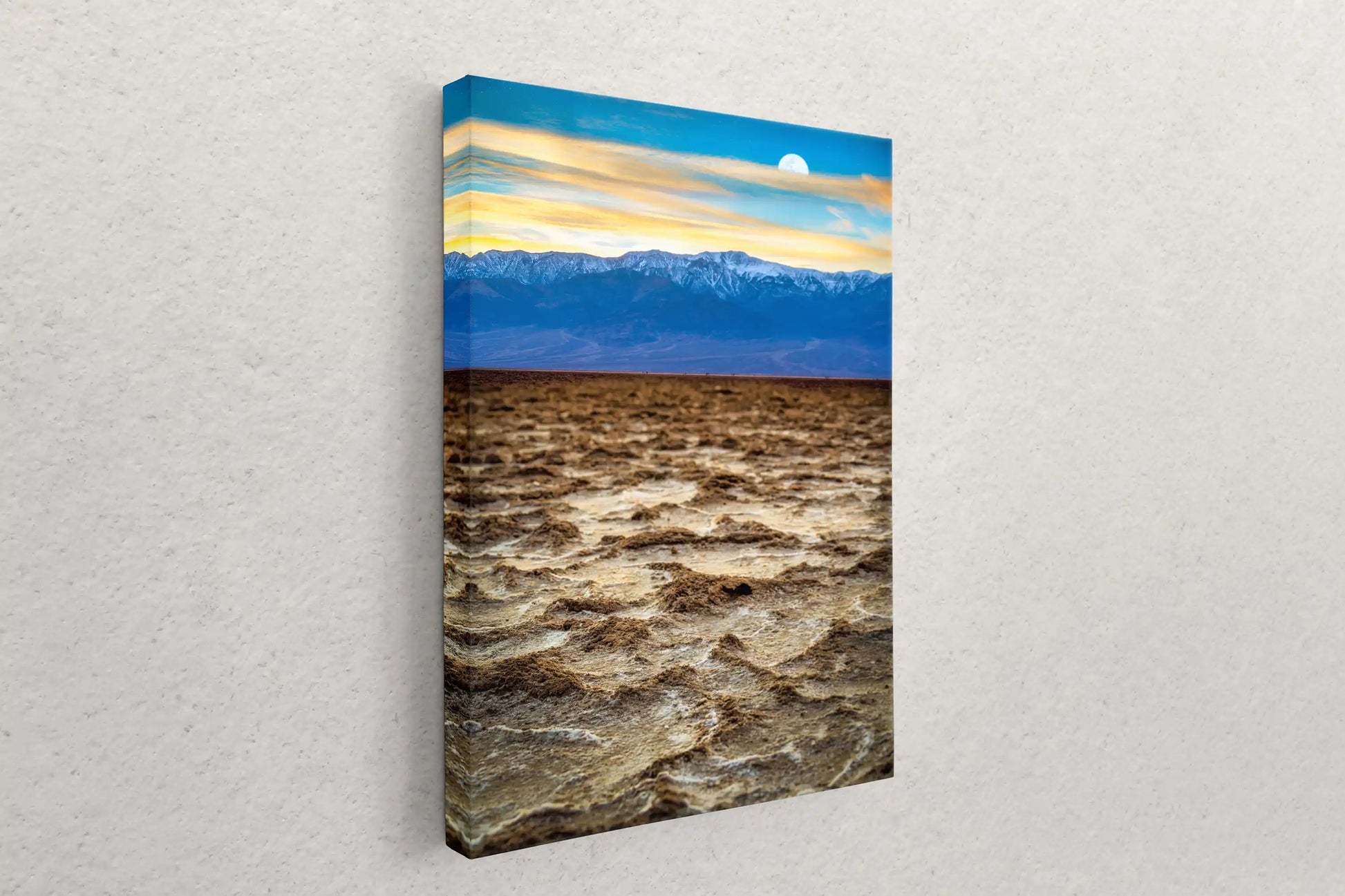 Left-hanging canvas on a wall showing the detailed texture of Badwater Basin's salt flats and the colorful sky of Death Valley.