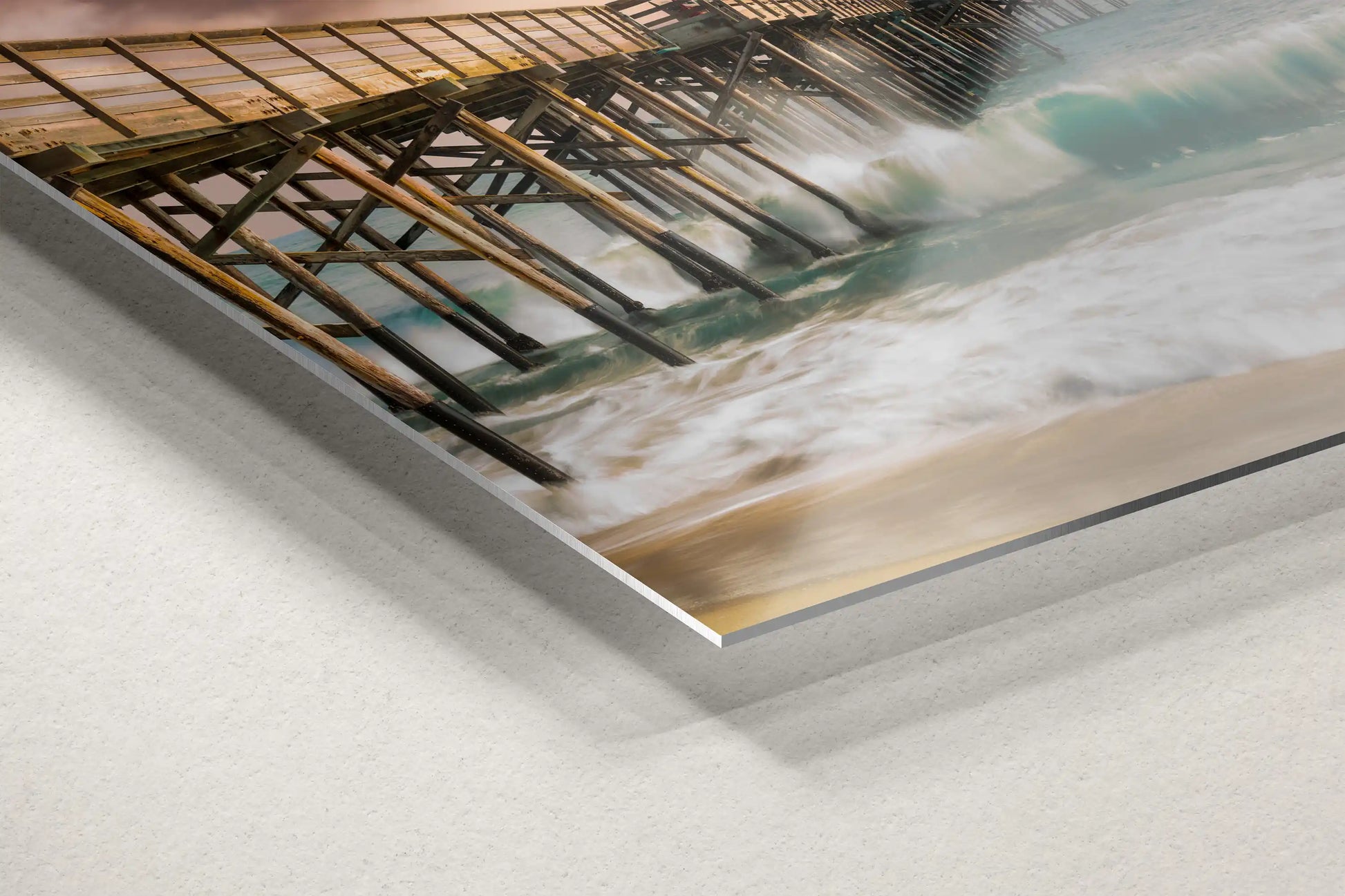 Close-up of a metal print showing the Balboa Pier of Newport Beach with detailed texture of the waves and the warm sunset, adding a sleek modern touch.