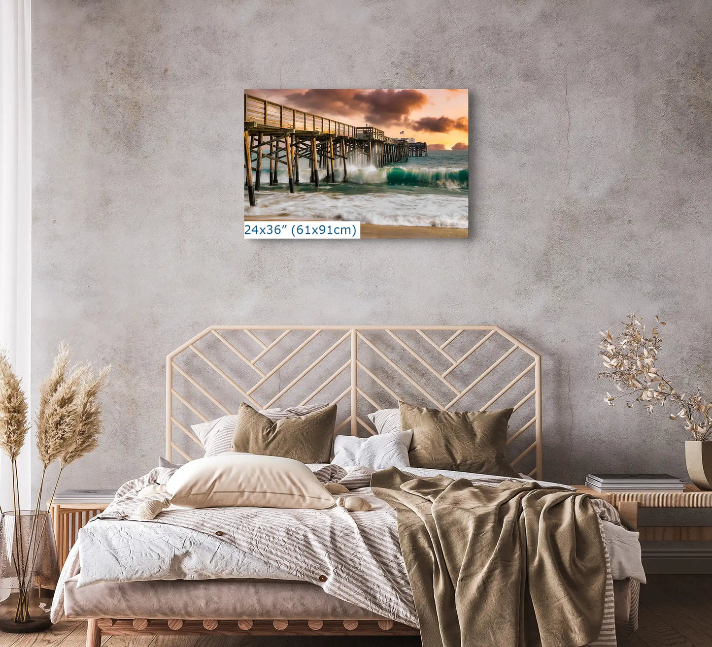 A large 24x36 inch canvas print of Balboa Pier at sunset, mounted above a bed, complementing the bedroom's neutral decor.