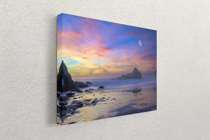 Side view of a canvas print on a wall, depicting a tranquil Big Sur sunset with moonrise, embodying calm and beauty.