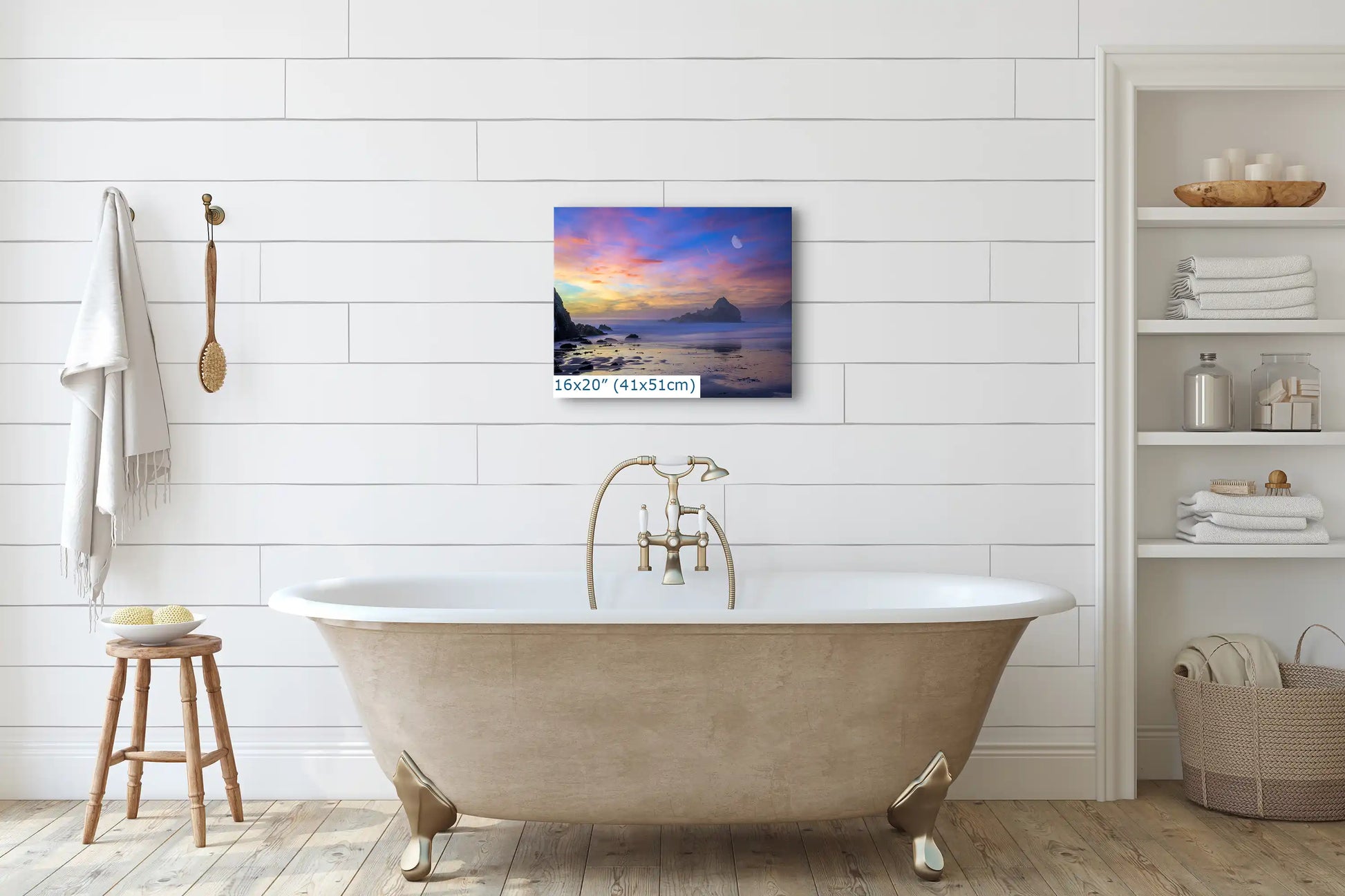 A 16x20-inch art of Big Sur's purple sand beach at sunset above a classic bathtub, adding tranquility to bathroom decor.