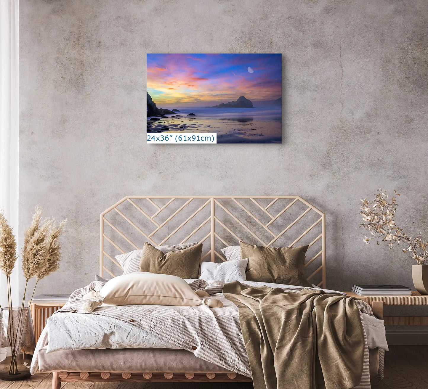 A 24x36-inch Big Sur sunset canvas creates a peaceful atmosphere in a modern bedroom, with the moon's rise over purple sands.
