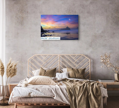 A 24x36-inch Big Sur sunset canvas creates a peaceful atmosphere in a modern bedroom, with the moon's rise over purple sands.