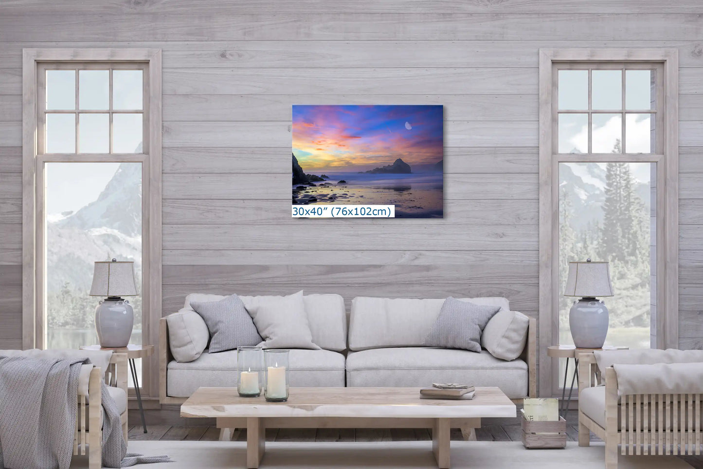 A large 30x40-inch canvas of Big Sur's purple beach at dusk adds a calming, luxurious touch to a cozy living room setting.
