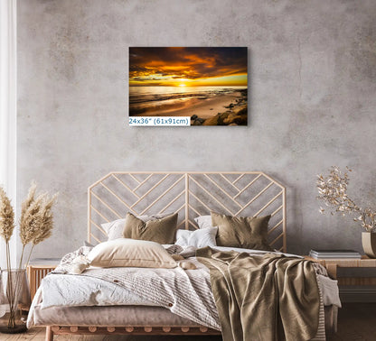 The 24x36 canvas art over a bed showcases a sunset at Hobson Beach, enveloping the room in the beach's awe-inspiring, calming ambiance.