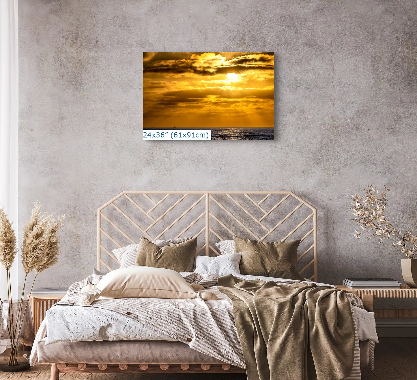 A 24"x36" canvas print showcasing a California sunset, hung above a bed, contributing to the tranquil decor of the bedroom.