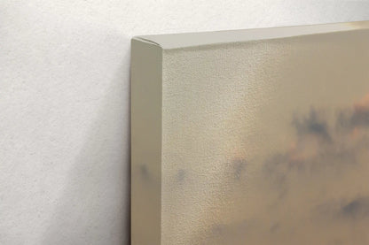 Detailed image of a canvas edge with a hint of a sunset print, showcasing the canvas's texture and the wrapped edge's neat fold.