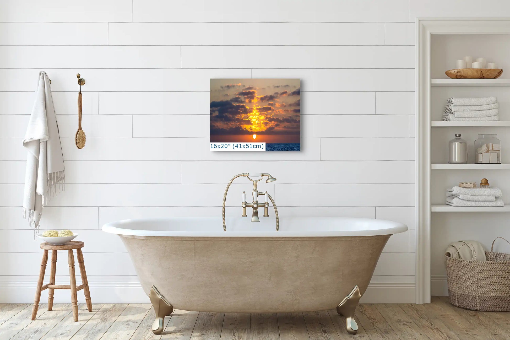 A serene bathroom setting featuring a 16x20 inch canvas print of a golden ocean sunset above the bathtub.