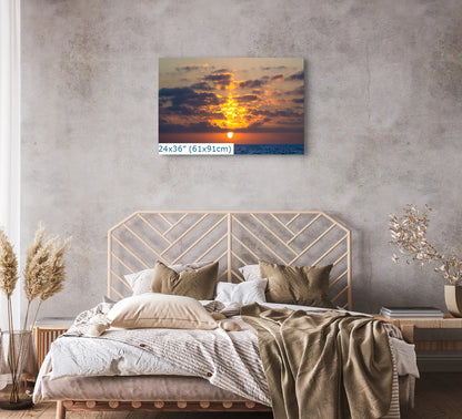 Bedroom with a 24x36 inch canvas print of an ocean sunset, adding a warm and inviting atmosphere.