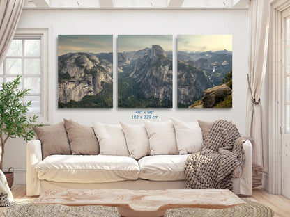 Spacious living room with a panoramic view of Glacier Point in Yosemite Valley, displayed in three large panels of 40x90-inch above a white couch.